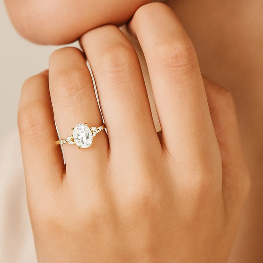 Gold Plated ring with a diamond on a hand against a beige background