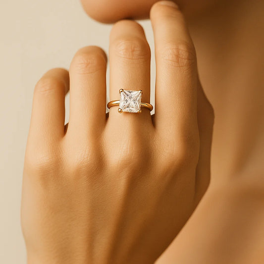 Gold Plated ring with a diamond on a hand against a beige background