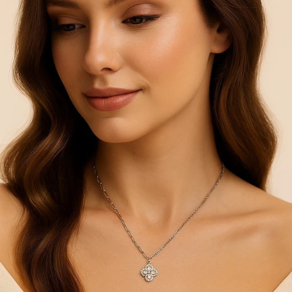 Woman wearing a delicate necklace with a floral pendant on a neutral background