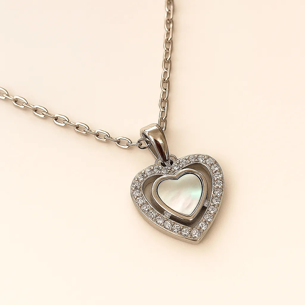 Heart-shaped pendant necklace with clear stones on a beige background
