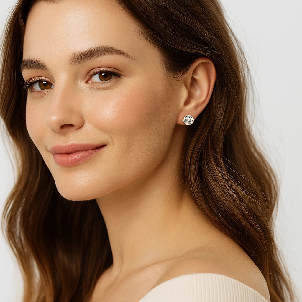 Close-up of a woman wearing diamond earrings with a plain background