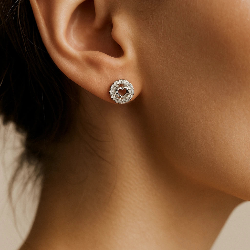 Close-up of an ear wearing a heart-shaped earring with a blurred background