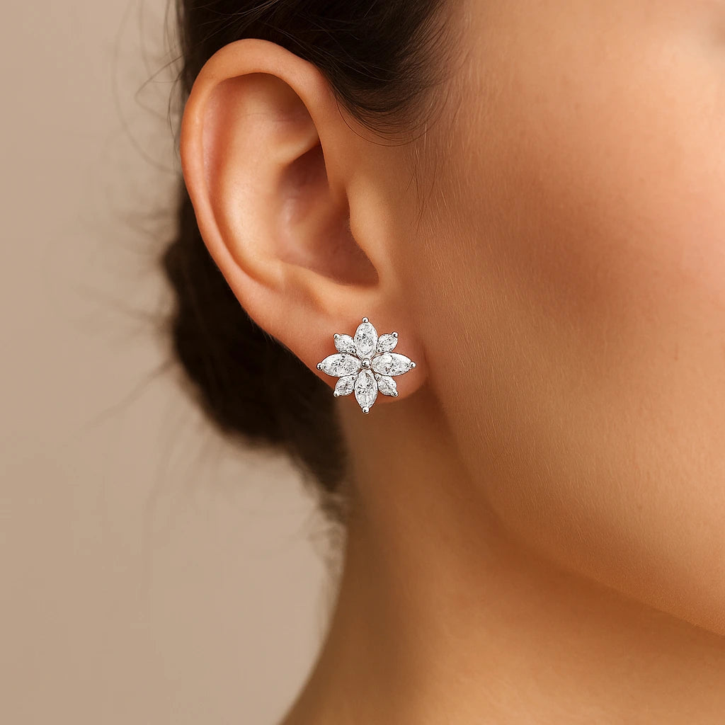 Close-up of an ear wearing a diamond flower earring with a neutral background