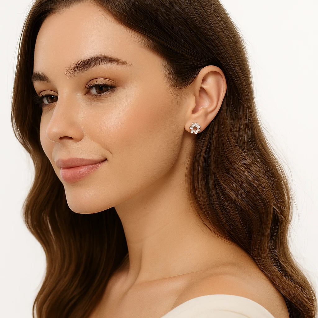 Close-up of a woman wearing floral earrings with a plain background