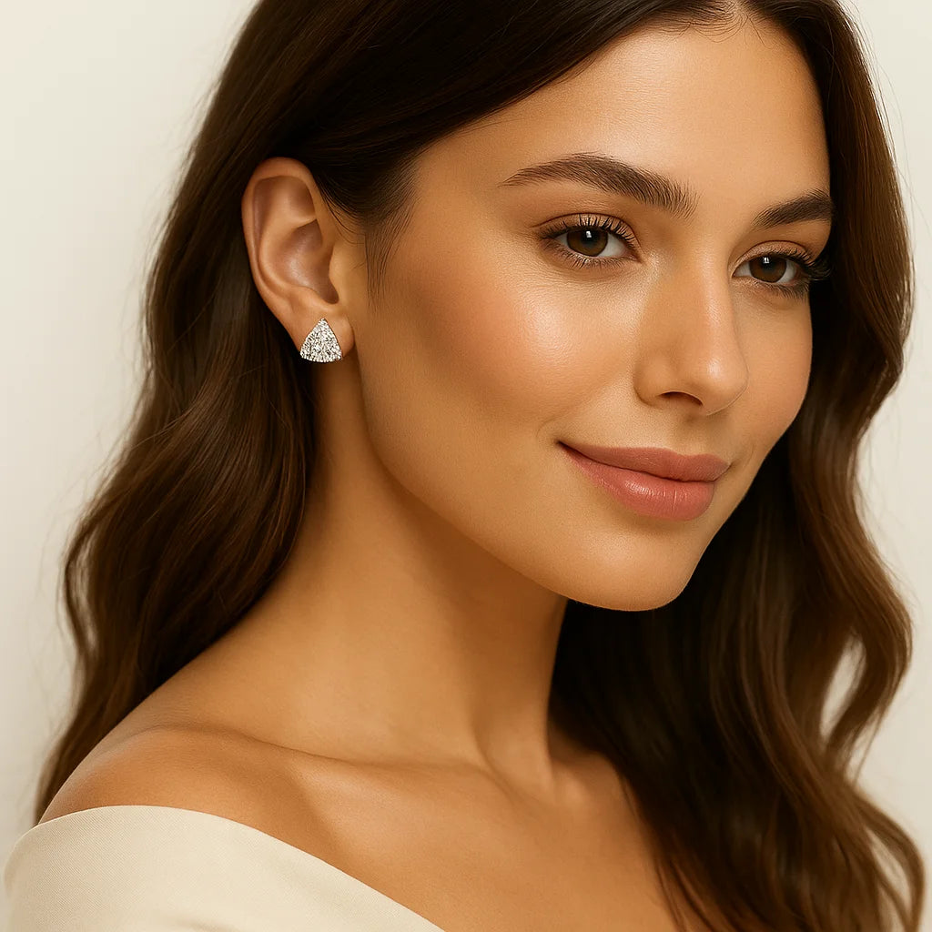 Woman wearing diamond earrings with a neutral background