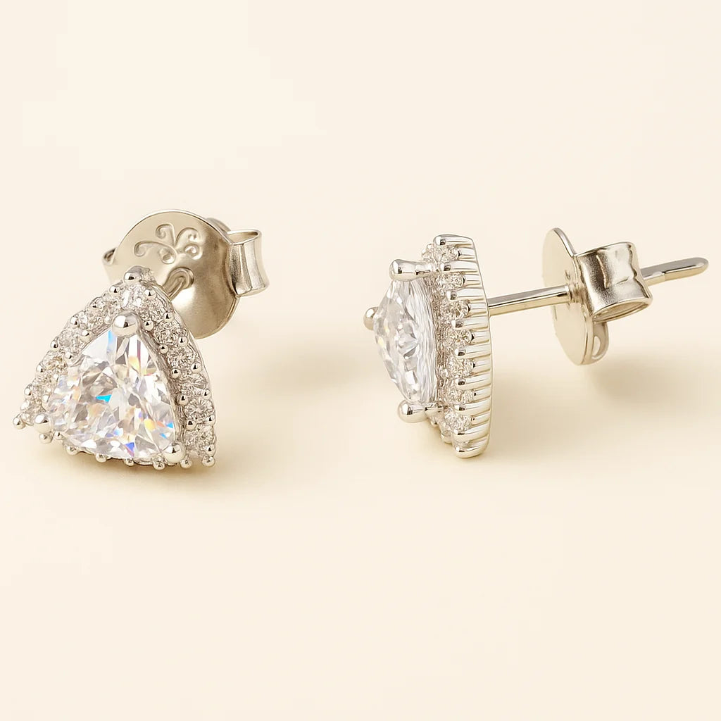 Pair of diamond earrings on a beige background
