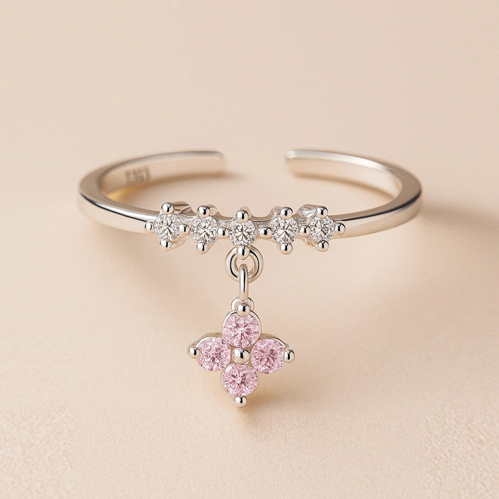 Silver bracelet with a pink flower charm on a beige background