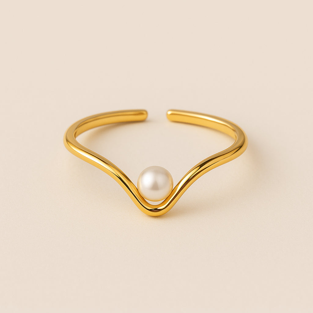 Golden ring with a pearl on a beige background