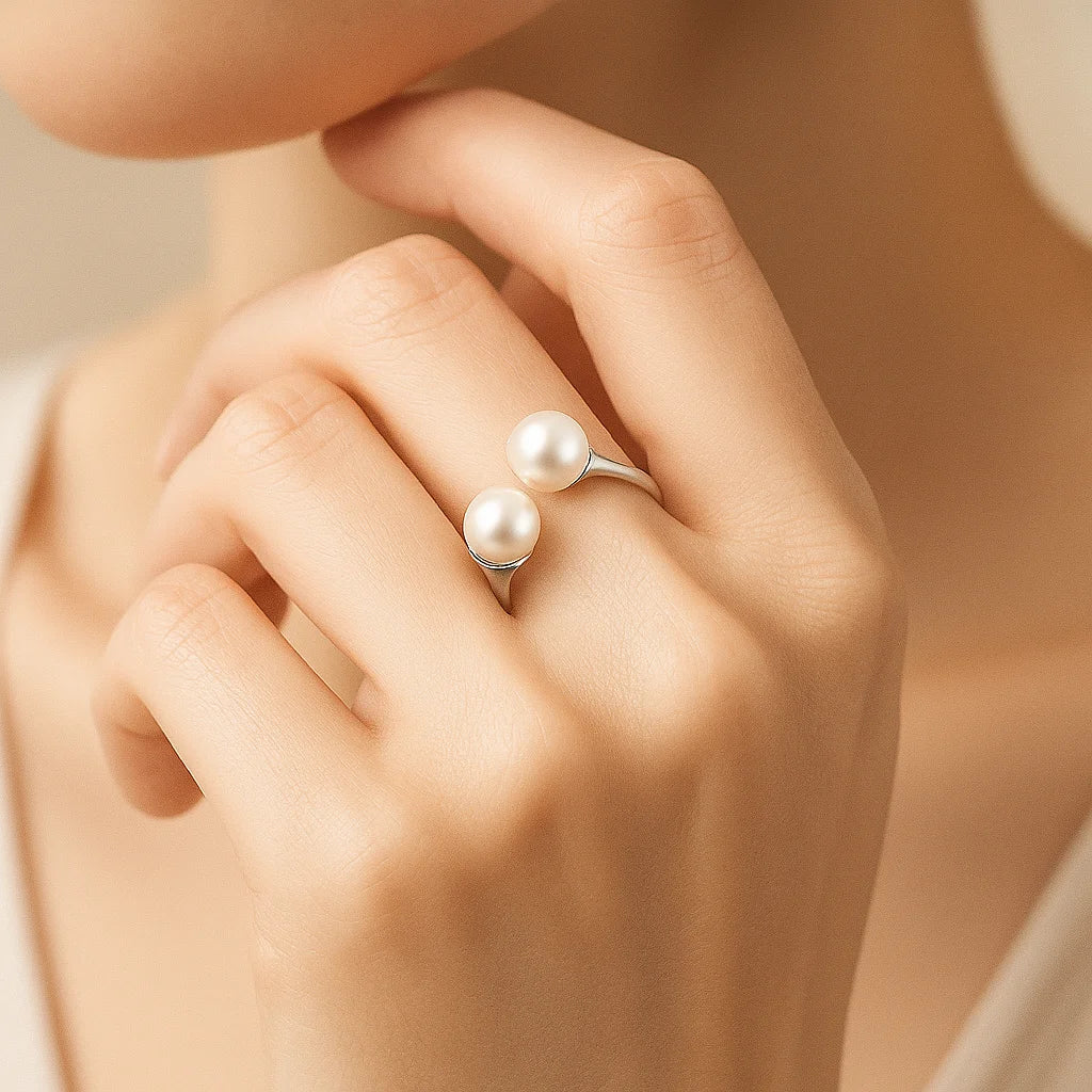 Hand wearing a pearl ring with a soft background
