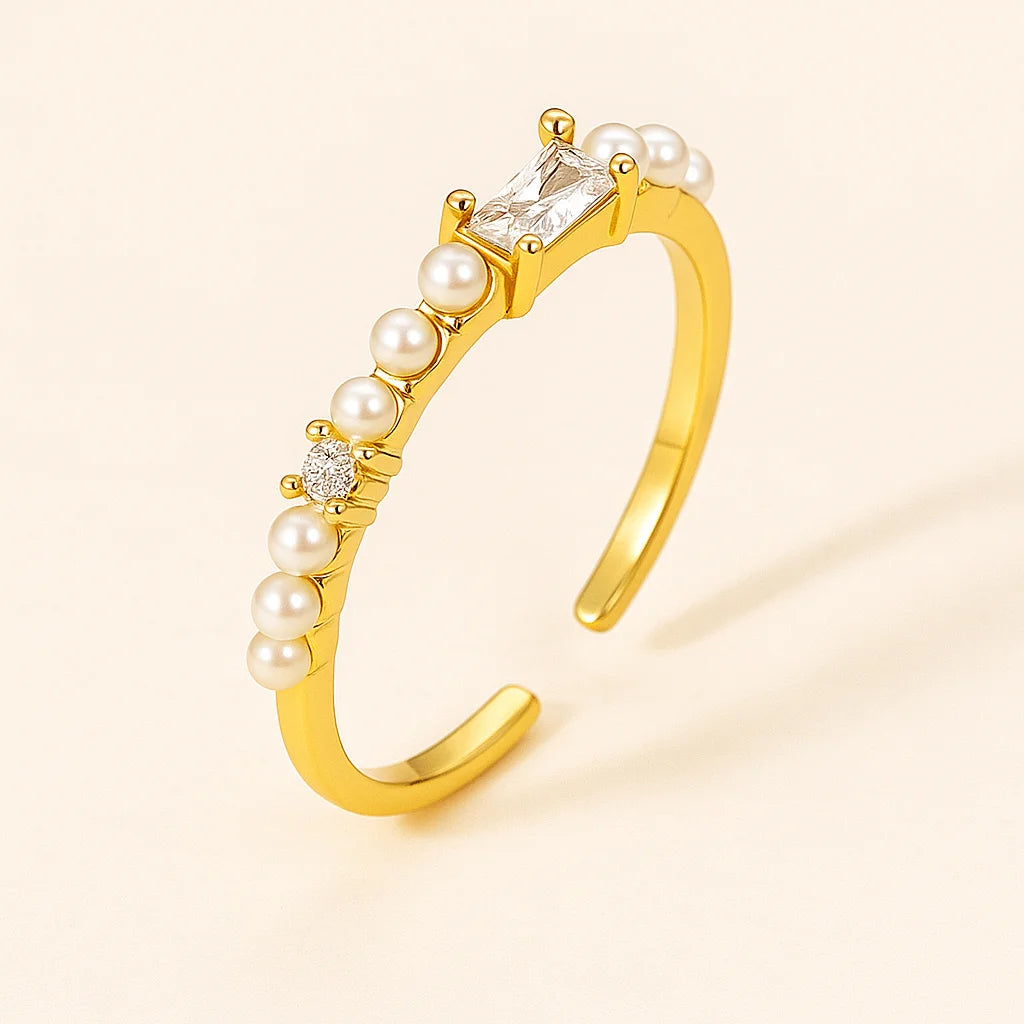 Golden ring with pearls and a diamond on a beige background