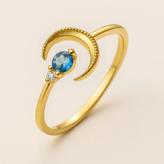 Golden ring with a blue gemstone and diamond on a beige background