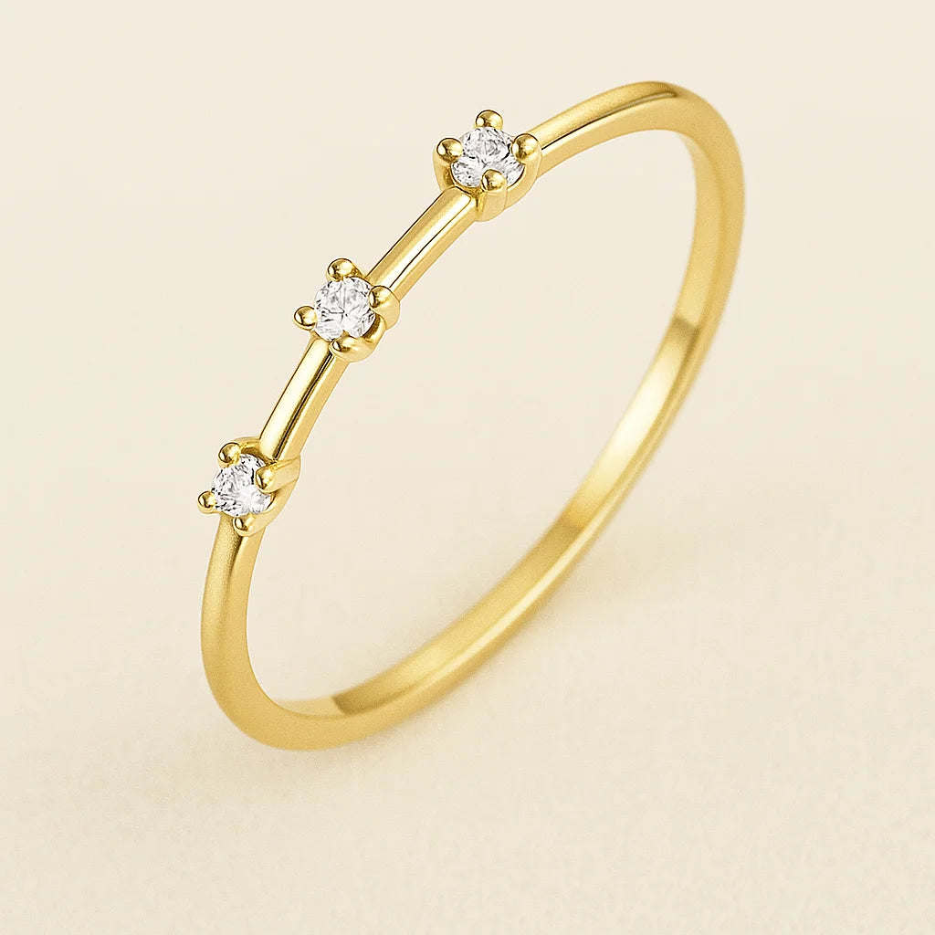 Golden ring with small diamonds on a beige background