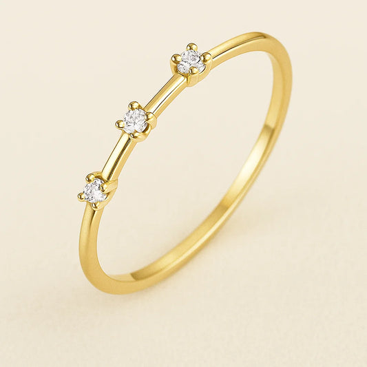 Golden ring with small diamonds on a beige background