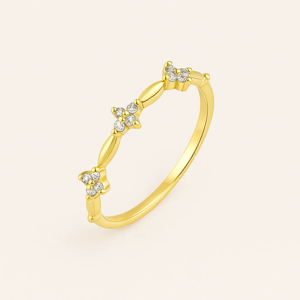 Golden ring with diamond accents on a light beige background