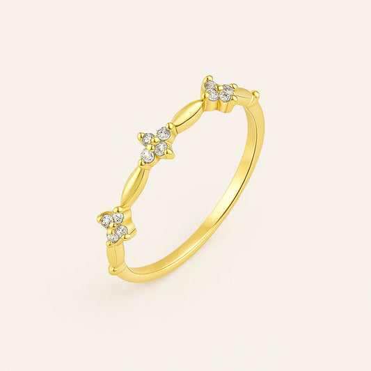 Golden ring with diamond accents on a light beige background