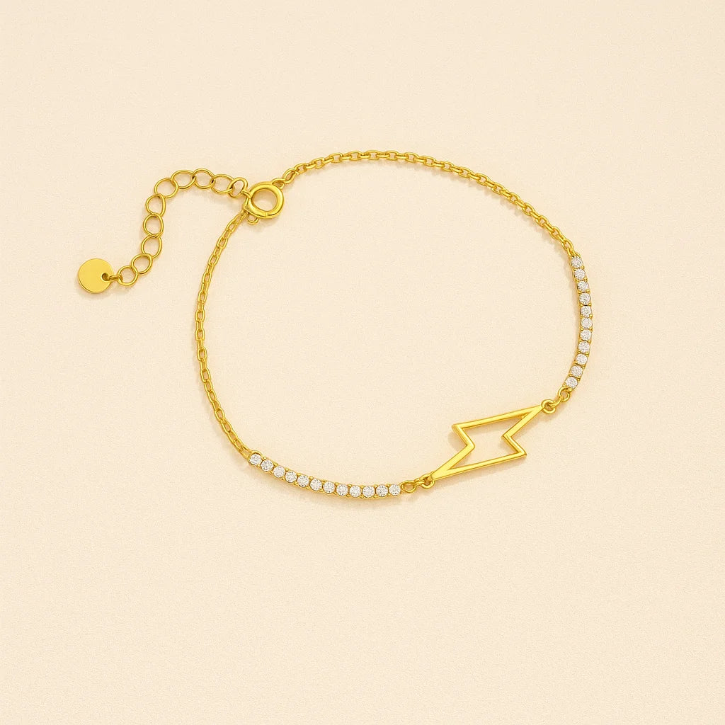 Golden bracelet with a lightning bolt design on a beige background