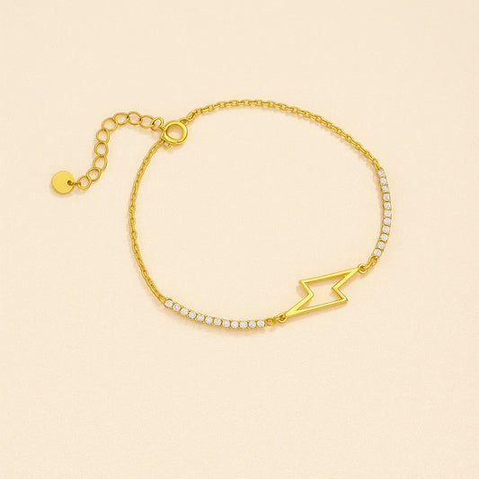 Golden bracelet with a lightning bolt design on a beige background