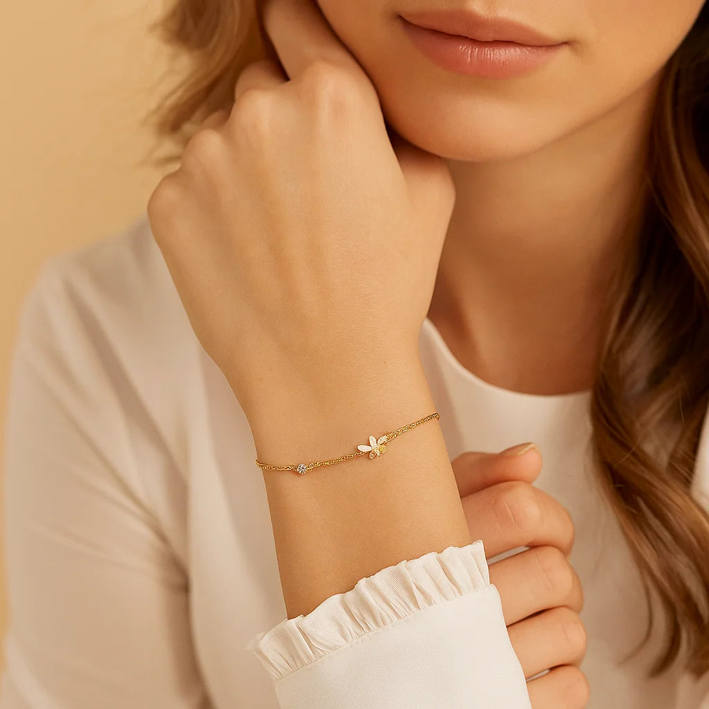 Close-up of a woman's wrist wearing a gold bracelet with a delicate design.