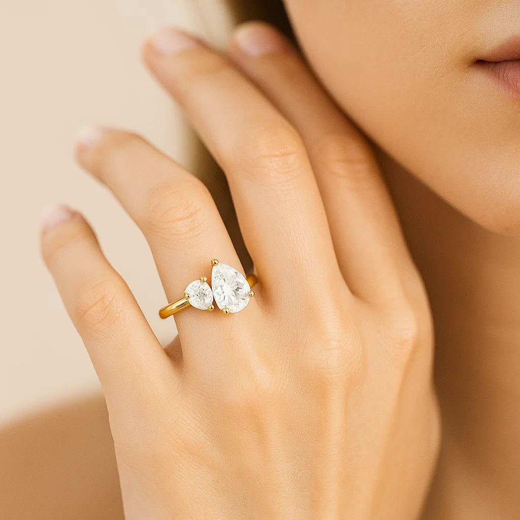Gold ring with a diamond on a hand against a neutral background
