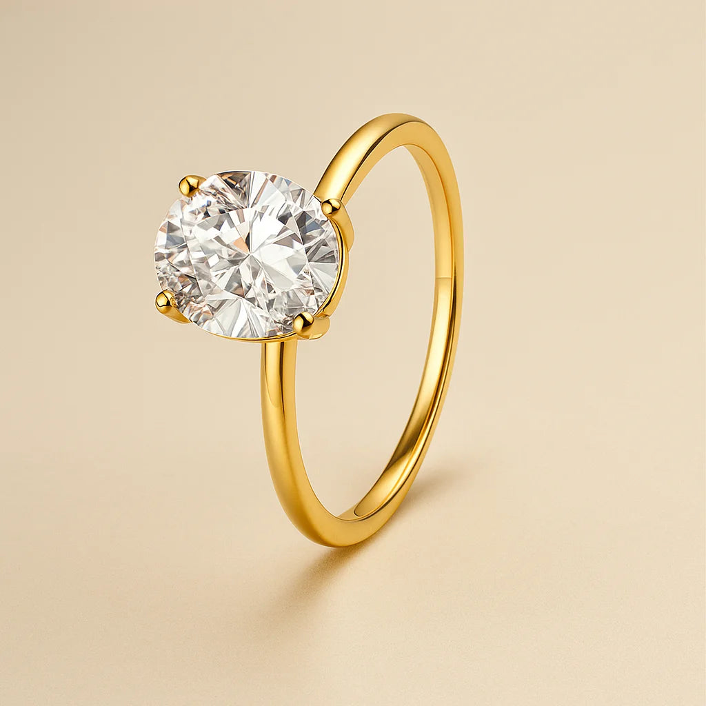 Gold ring with a clear gemstone on a beige background