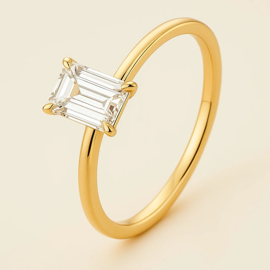 Gold plated  ring with a clear gemstone on a beige background