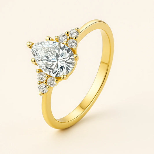 Gold plated ring with a Pear -shaped diamond on a light beige background