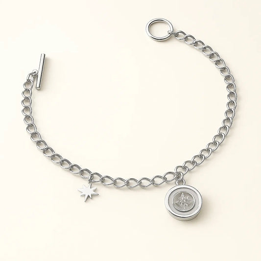 Silver bracelet with star and round charm on a white background
