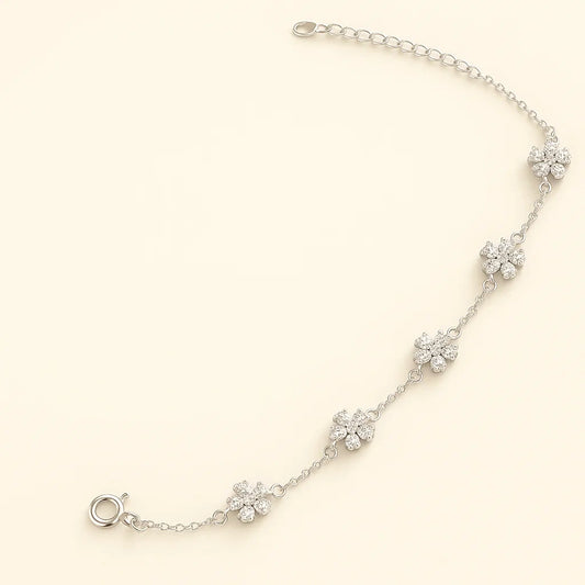 Three color variations of a 925 sterling silver flower chain bracelet: silver with clear stones, gold-plated with green stones, and gold-plated with pink stones.