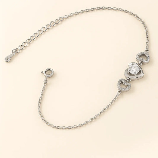 Silver bracelet with heart-shaped charms on a beige background