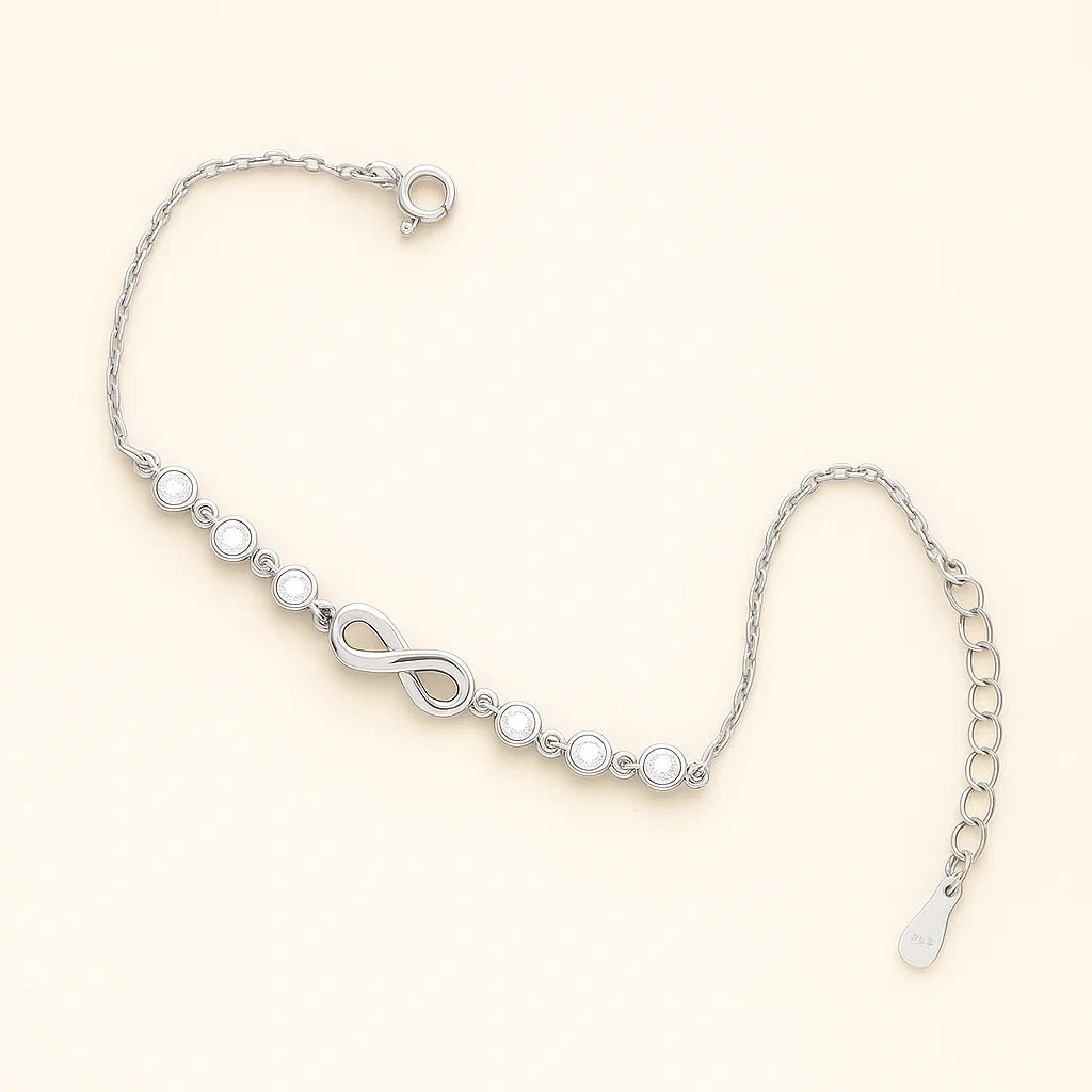 Silver bracelet with infinity symbol on a light beige background