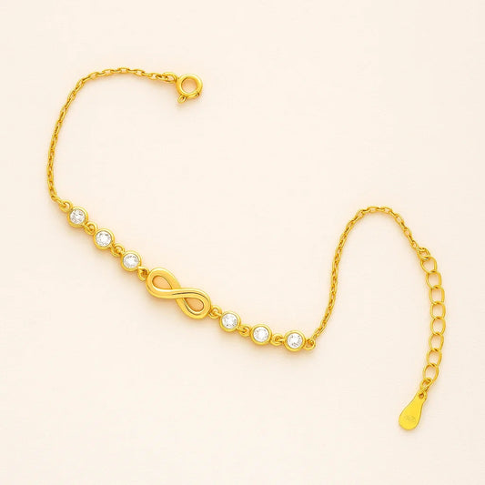 An elegant gold-plated 925 sterling silver bracelet featuring an infinity symbol charm and six sparkling clear stones.