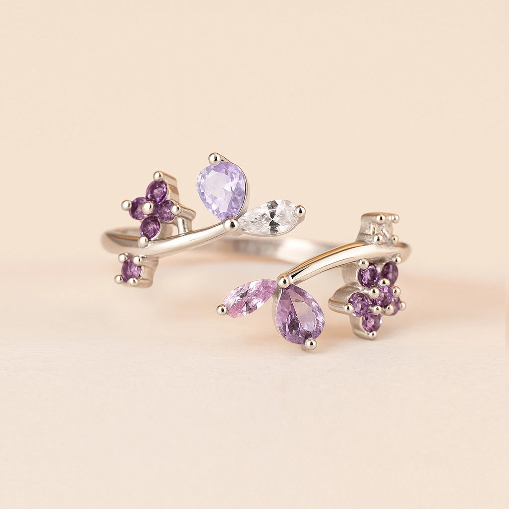 Silver ring with purple gemstones on a beige background