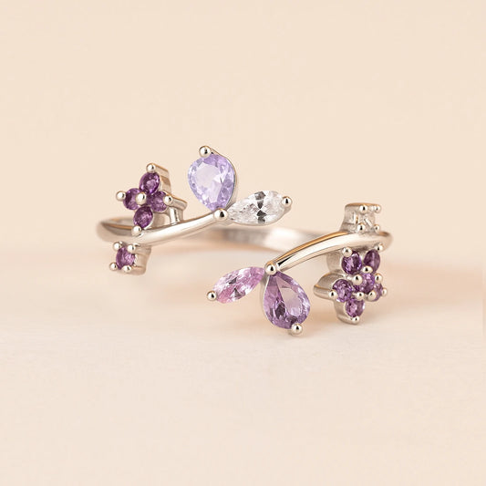 Silver ring with purple gemstones on a beige background