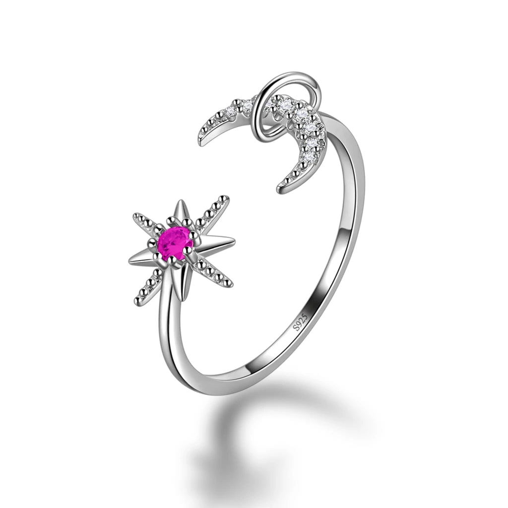 Silver ring with star and moon design and pink gemstone on a white background