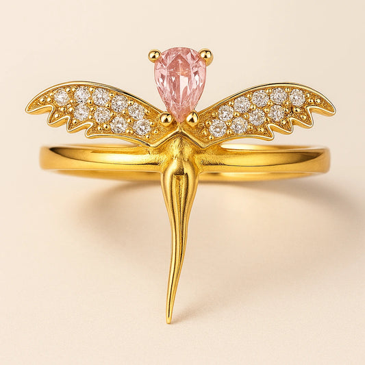 Gold ring with pink gemstone and diamond accents on a beige background