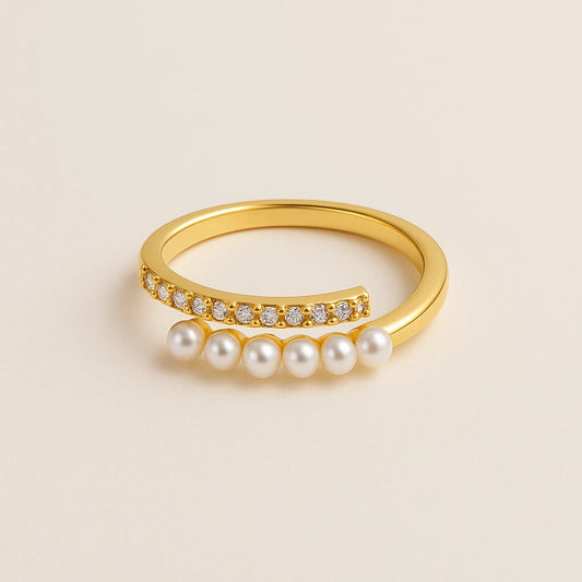 Golden ring with pearls and small diamonds on a beige background