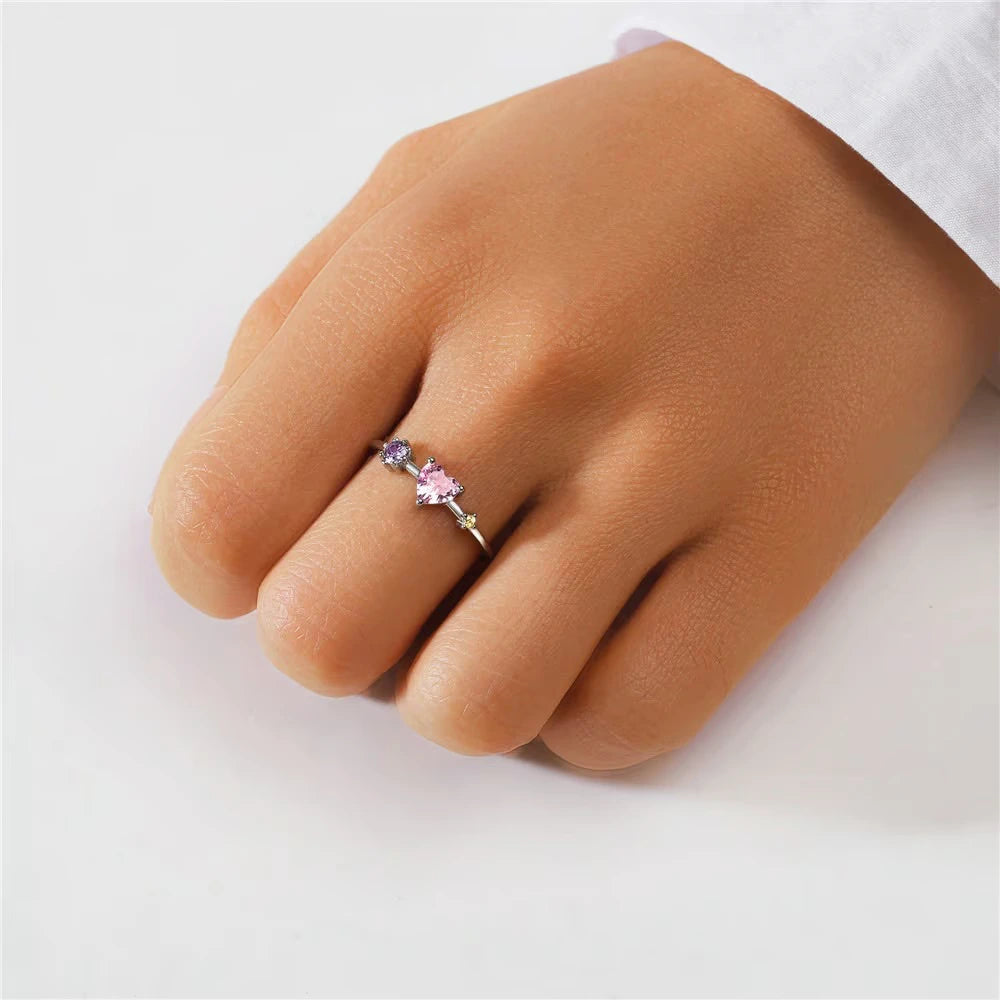 Hand wearing a silver ring on a light background