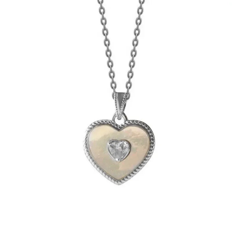 Heart-shaped pendant with a diamond on a chain against a white background