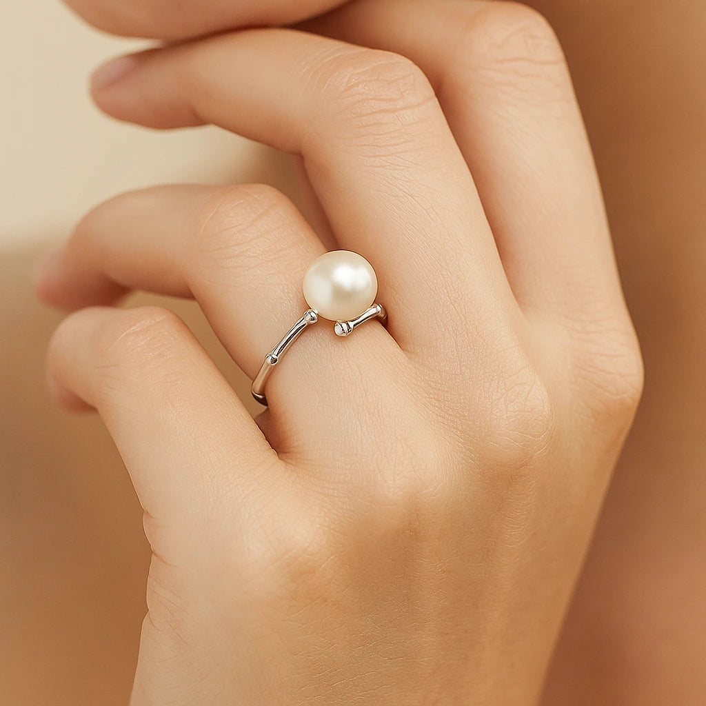 Pearl ring on a hand against a neutral background