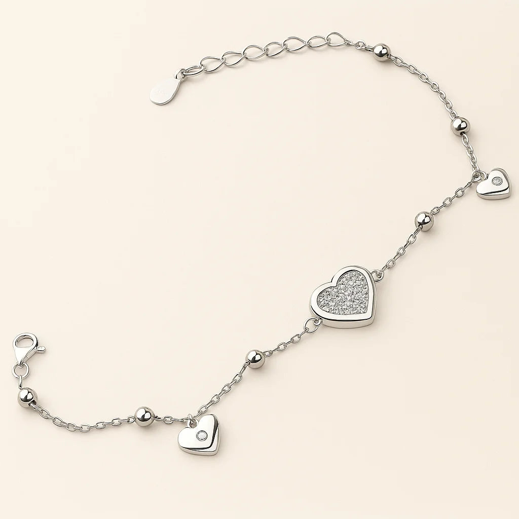 A beautiful gold-plated sterling silver bracelet with a mix of polished and pavé heart charms with cubic zirconia stones.