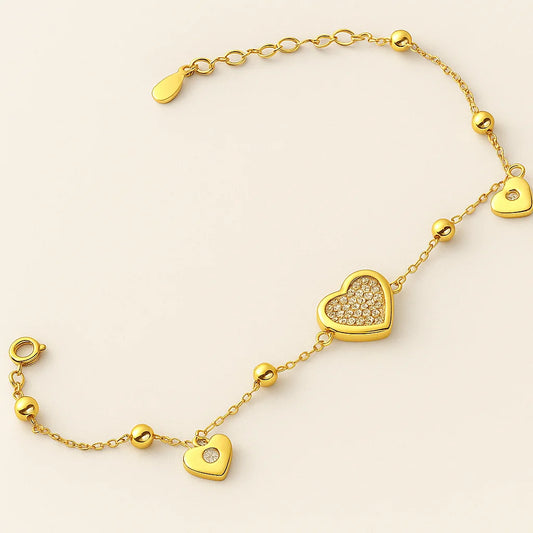 A beautiful gold-plated sterling silver bracelet with a mix of polished and pavé heart charms with cubic zirconia stones.