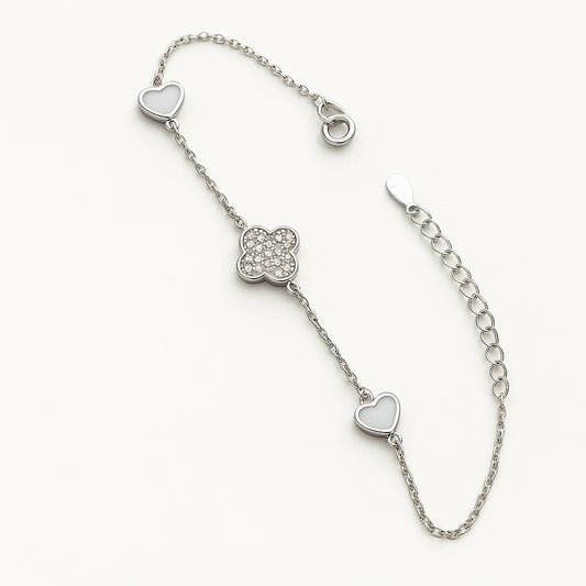 A beautiful gold-plated sterling silver bracelet featuring a central pavé clover charm flanked by two heart charms.