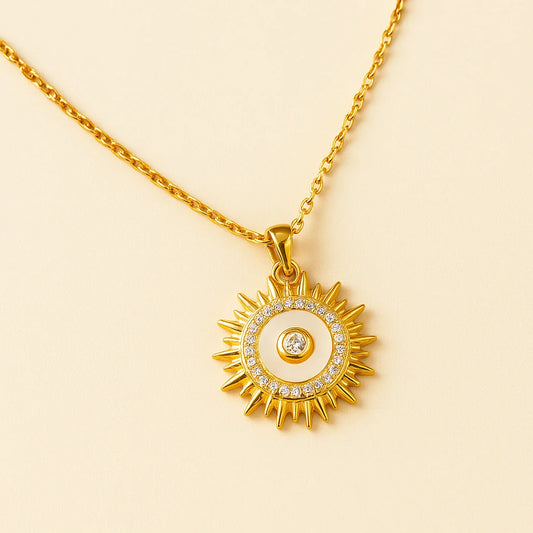 A radiant gold-plated sterling silver necklace with a sunburst pendant featuring a mother-of-pearl inlay and sparkling cubic zirconia stones.