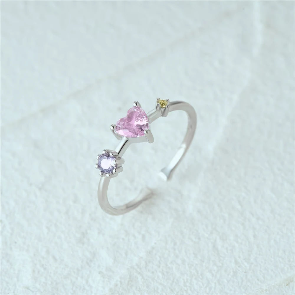 Silver ring with pink and purple gemstones on a white background