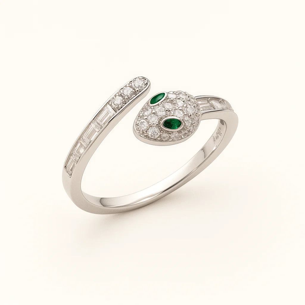 A close-up shot of a unique snake-shaped 925 sterling silver ring with emerald-colored eyes.