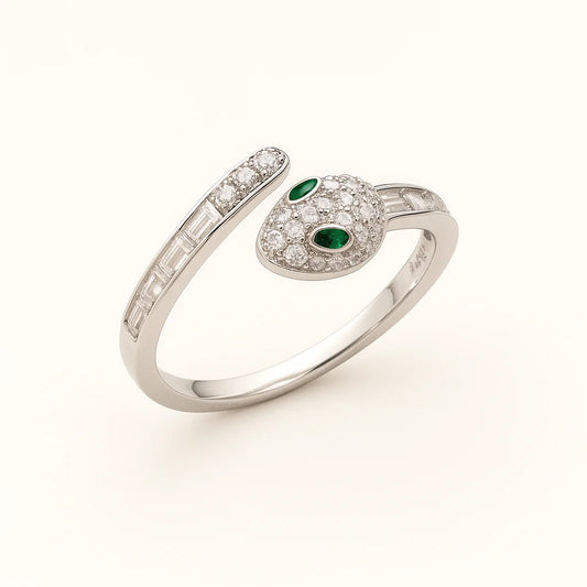 A close-up shot of a unique snake-shaped 925 sterling silver ring with emerald-colored eyes.