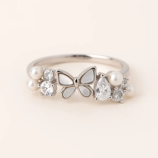 A 925 sterling silver ring with a mother-of-pearl butterfly and clusters of cubic zirconia stones and pearls.