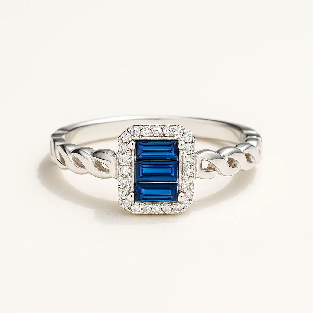 A 925 sterling silver ring with a central blue rectangle-shaped stone, a sparkling halo, and a twisted band.