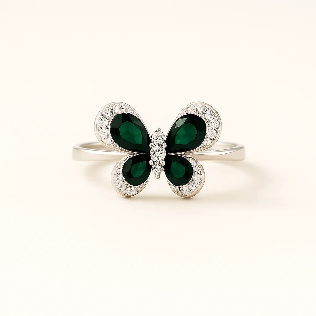 A 925 sterling silver ring with a butterfly centerpiece, with wings of blue or green pear-cut stones and a halo of pavé cubic zirconia.