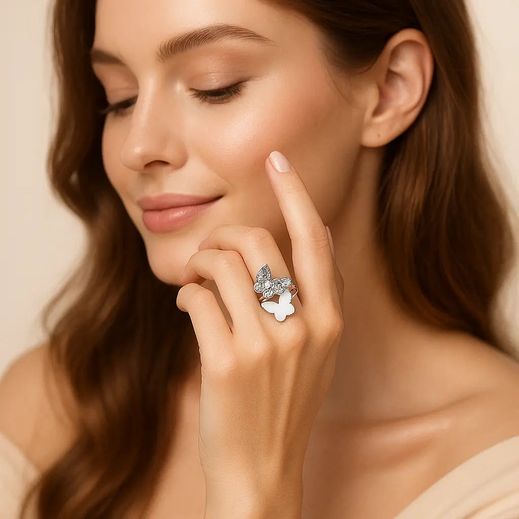 Woman wearing a silver ring with a butterfly design on a neutral background